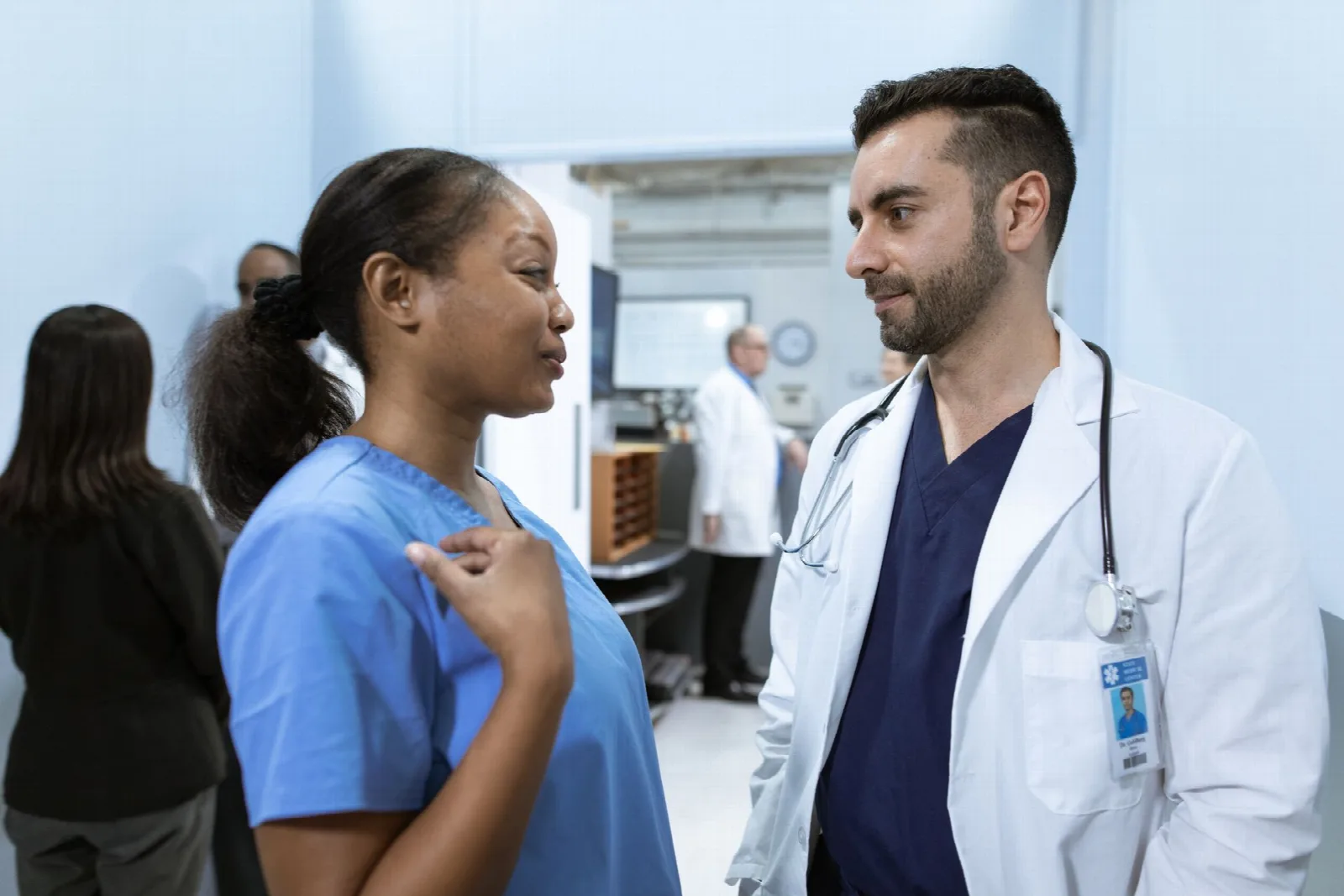 Médica y médico conversan en un centro de salud